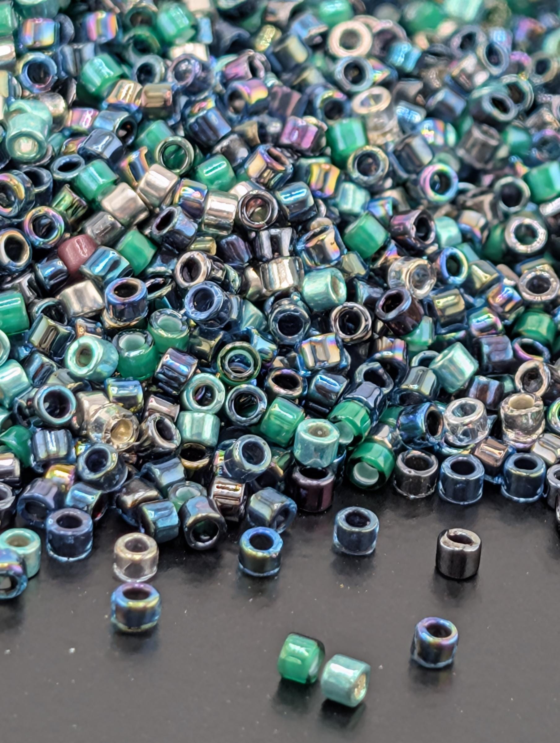 A pile of multicolored glass beads scattered on a dark surface.