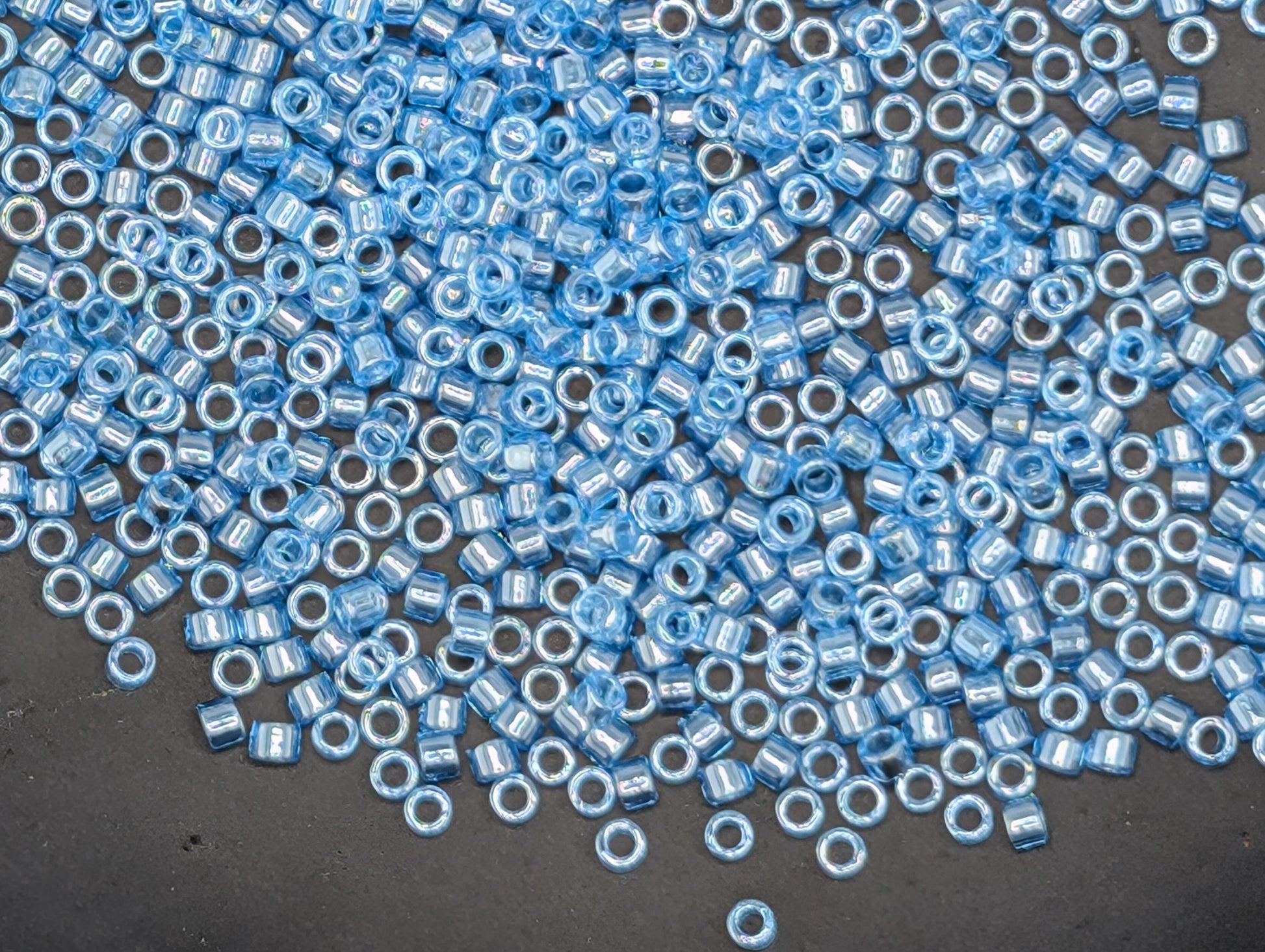 a large number of small, round blue beads scattered across a dark surface.