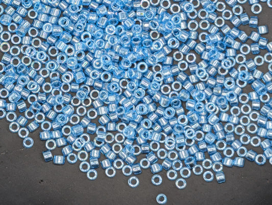 a large number of small, round blue beads scattered across a dark surface.