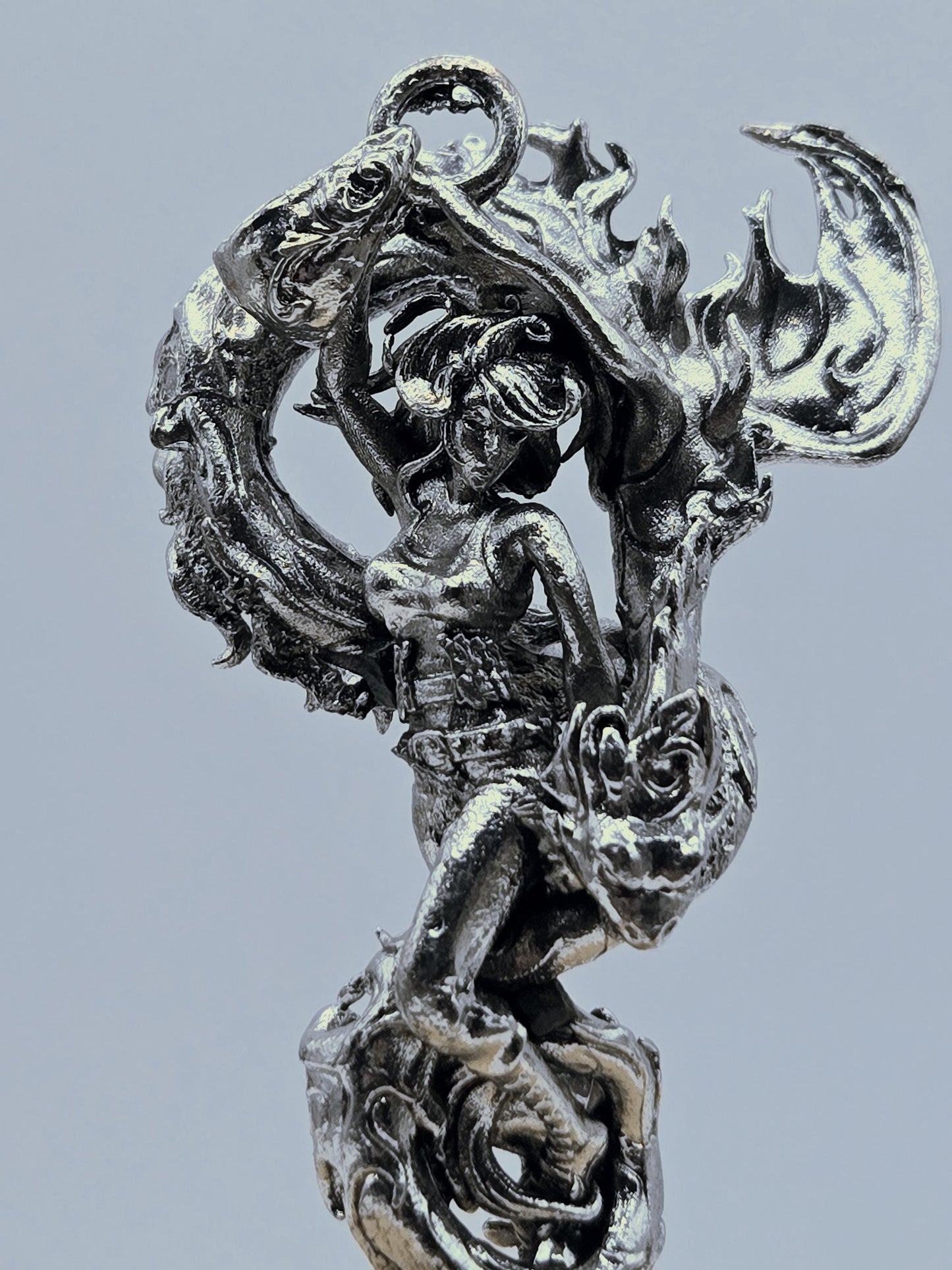 a detailed, intricate metal sculpture of a dragon-like creature with flowing, organic shapes and patterns.