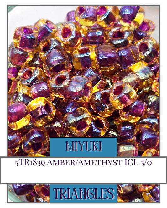 a pile of purple and yellow glass beads