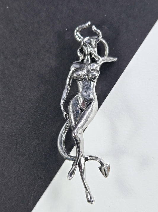 A silver-colored metal sculpture depicting a human figure in a reclining position.