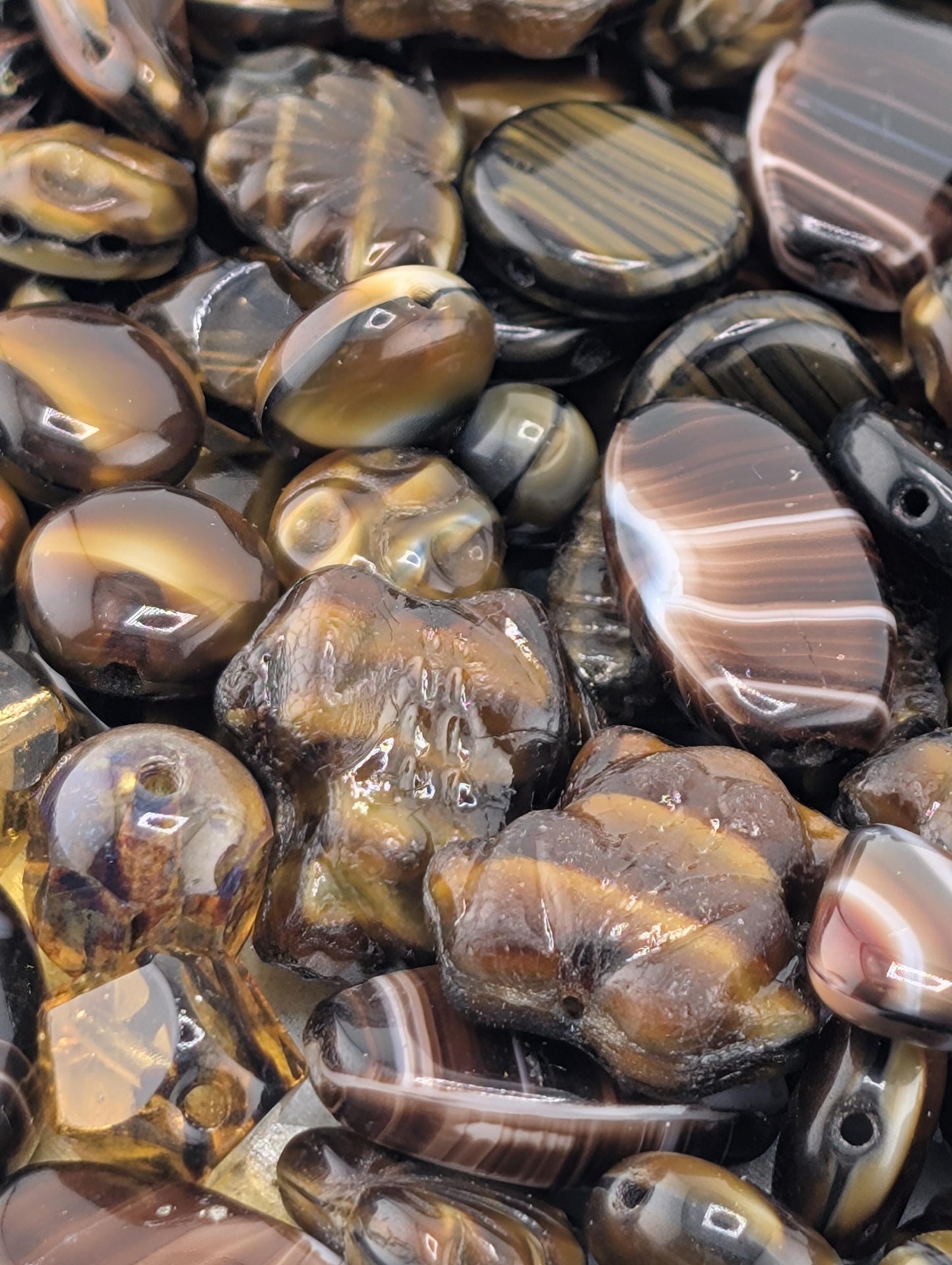 a close-up view of various colored beads and stones, including brown, black, and gold-toned pieces.