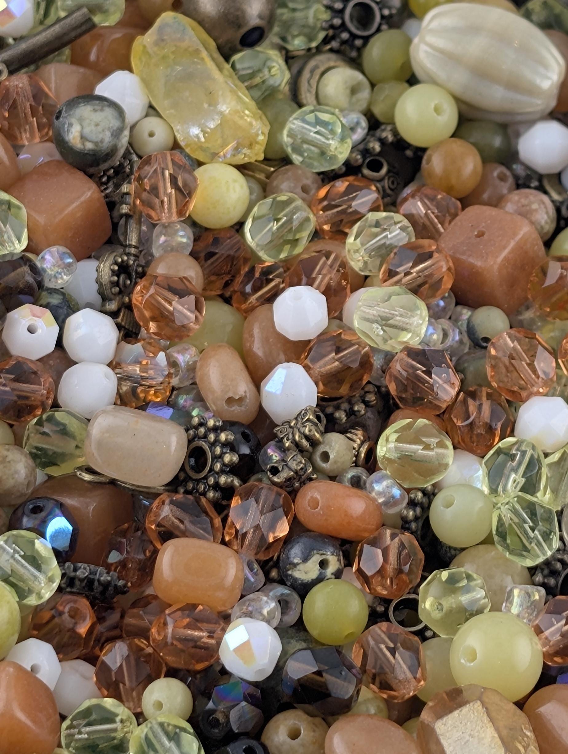 The image is a close-up of a variety of colorful beads and beads, including glass beads, metal beads, and other materials, creating a visually appealing and diverse collection.