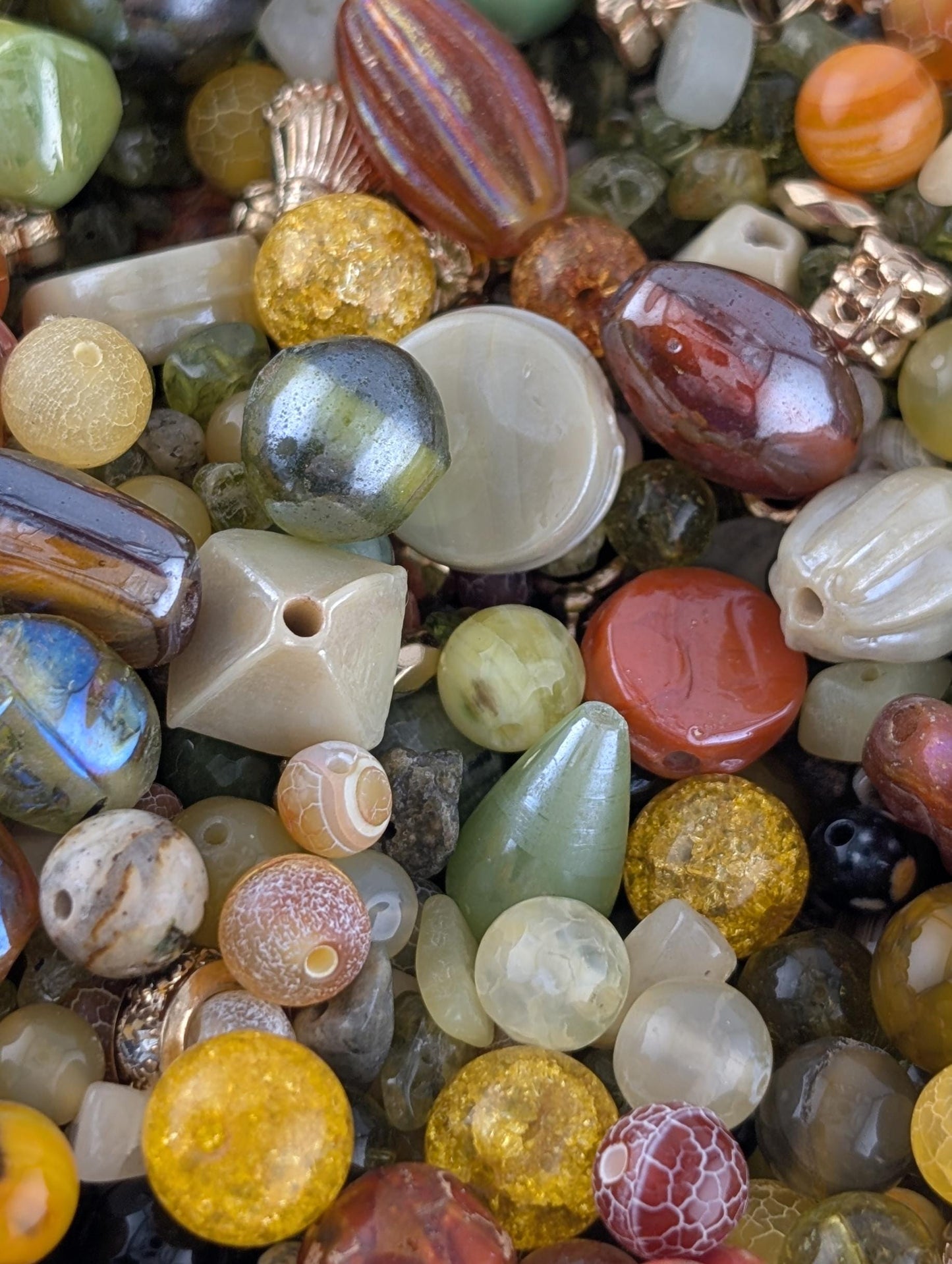 The image is a close-up of a variety of colorful beads and glass beads, including multicolored glass beads, multicolored glass beads, and multicolored glass beads.