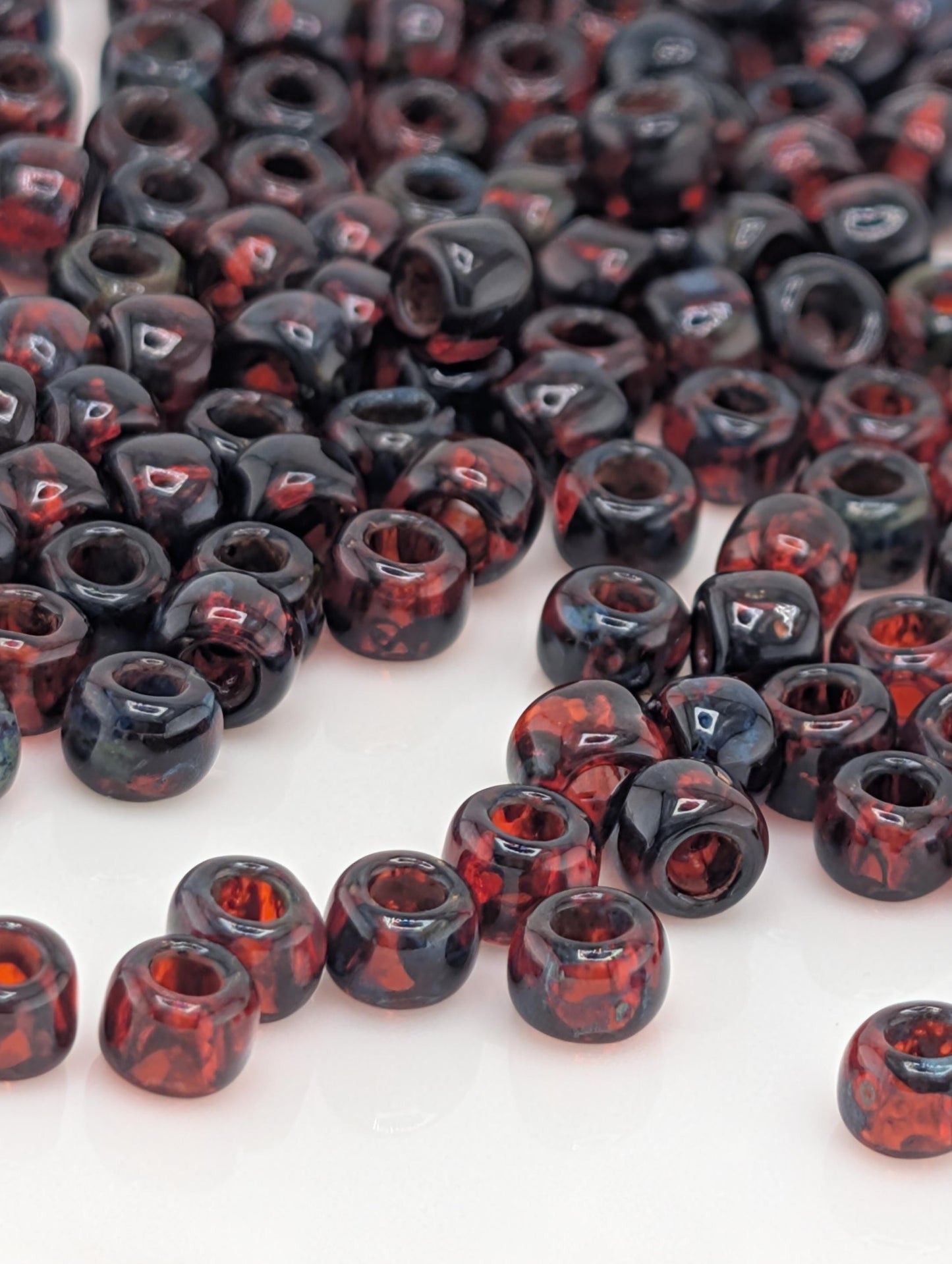 a collection of red and black beads scattered across a white surface.