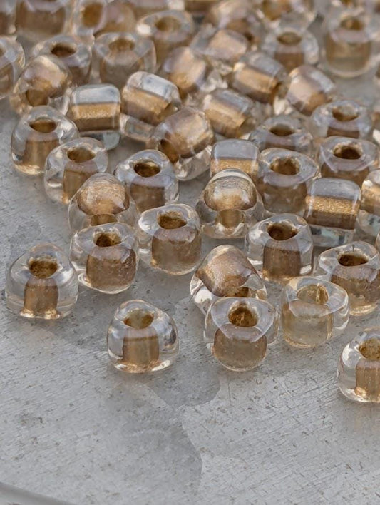 a collection of clear glass beads scattered on a surface, with a variety of shapes and sizes.
