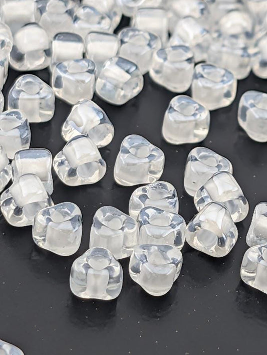 a collection of clear, transparent beads scattered across a dark background.