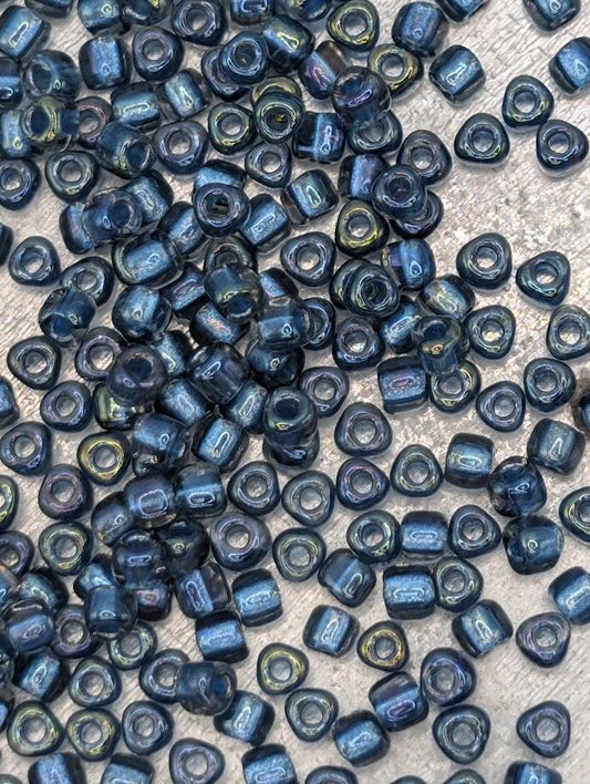 a collection of small, round beads in various shades of blue, scattered across a surface.