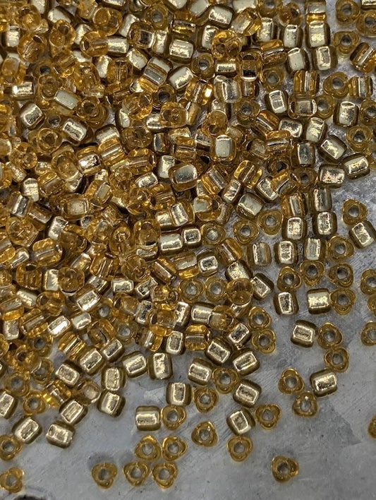 a close-up view of numerous small, golden-colored beads scattered across a surface.