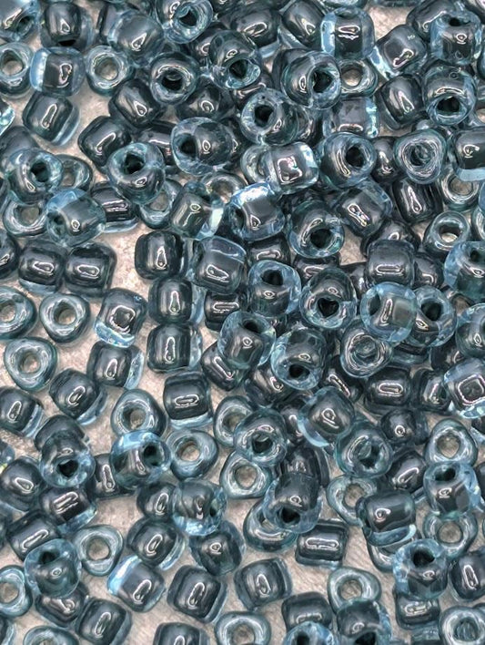 a close-up view of numerous small, clear beads in various shades of blue, scattered across a surface.