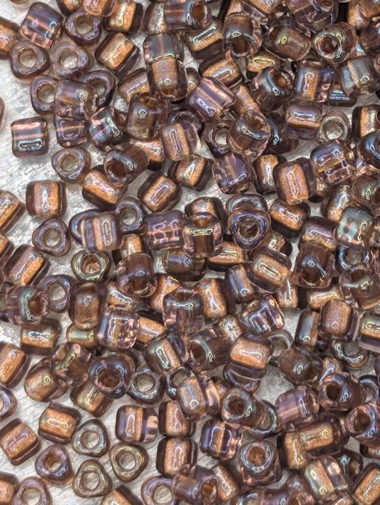 a close-up view of numerous small, brown glass beads scattered across a surface.