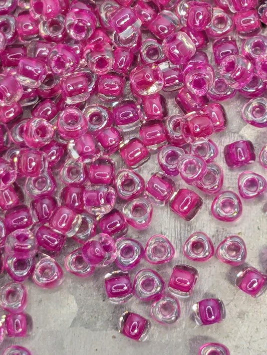 a close-up view of numerous clear and pink beads scattered across a surface.
