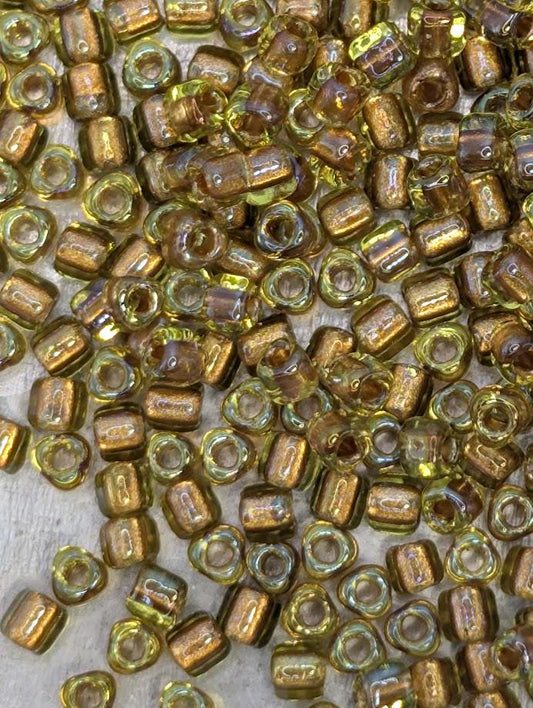 a close-up view of numerous small, round beads in various shades of yellow and gold, scattered across a surface.