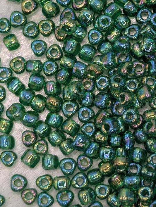 a close-up view of numerous green glass beads scattered across a surface.