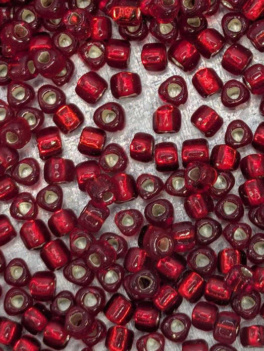 a close-up view of numerous red beads scattered across a surface.