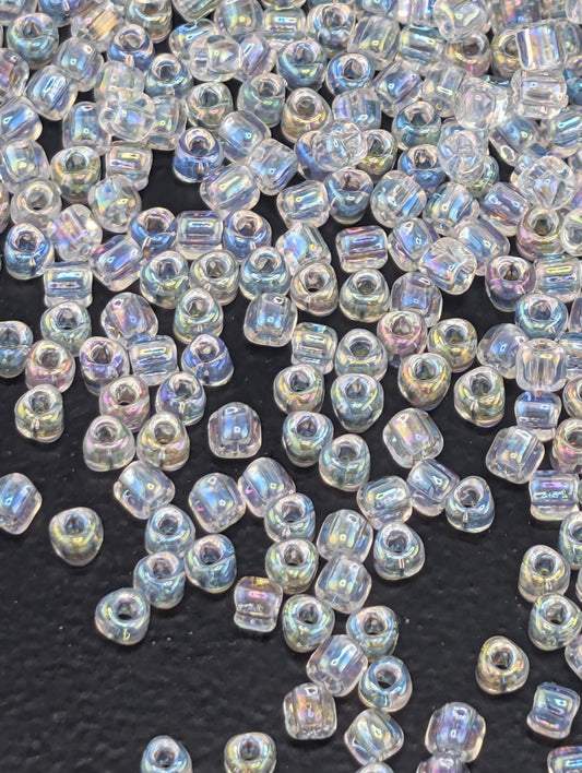 a collection of clear, iridescent beads scattered across a dark surface.