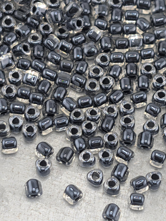 a large number of black and clear beads scattered across a surface.