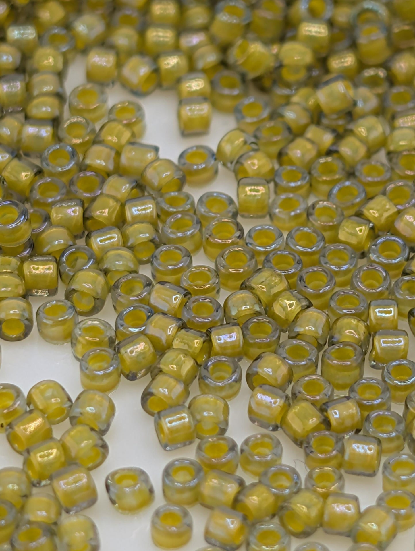 numerous small, yellow glass beads scattered across a surface.