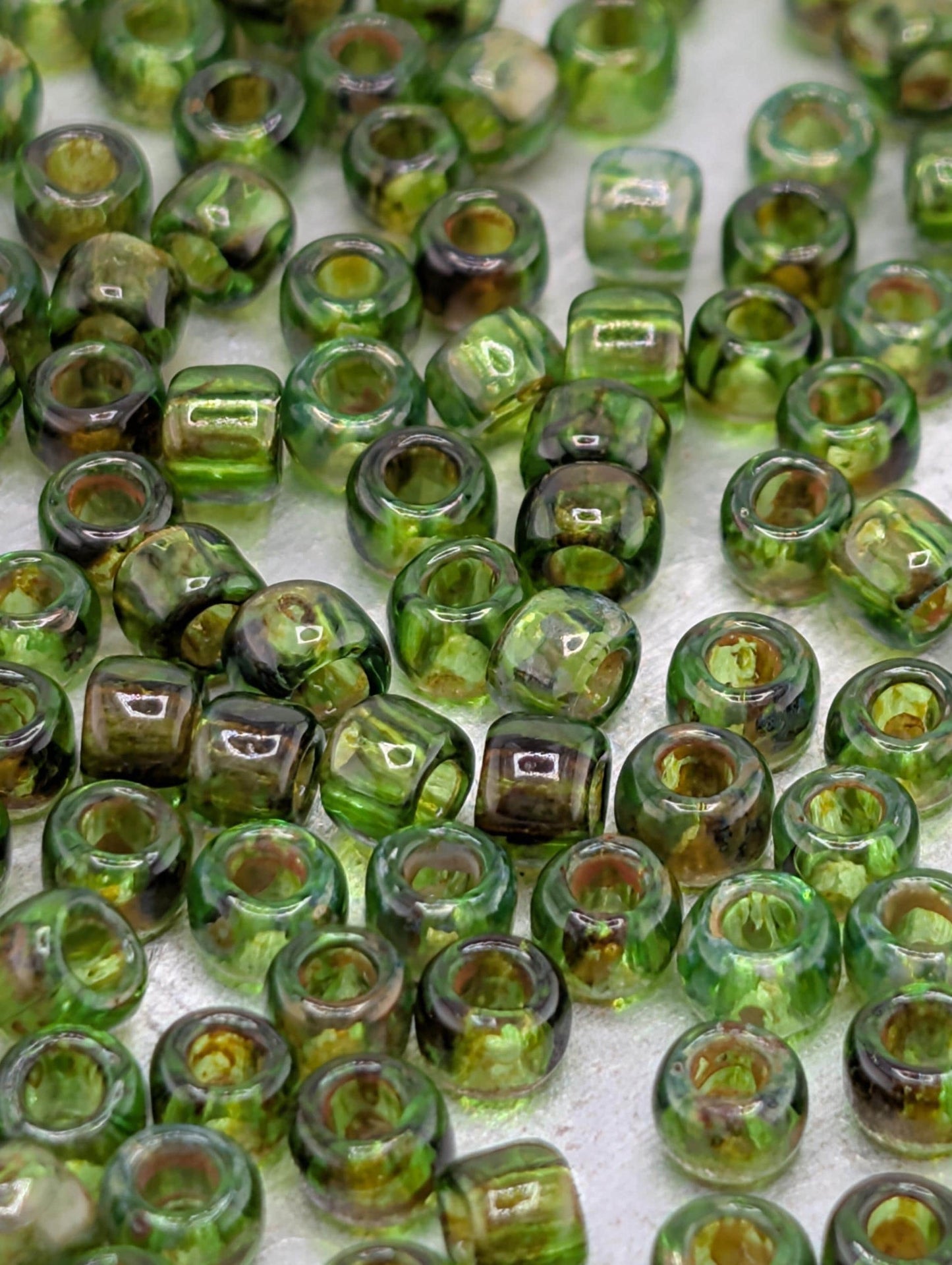 a collection of green glass beads scattered across a surface.