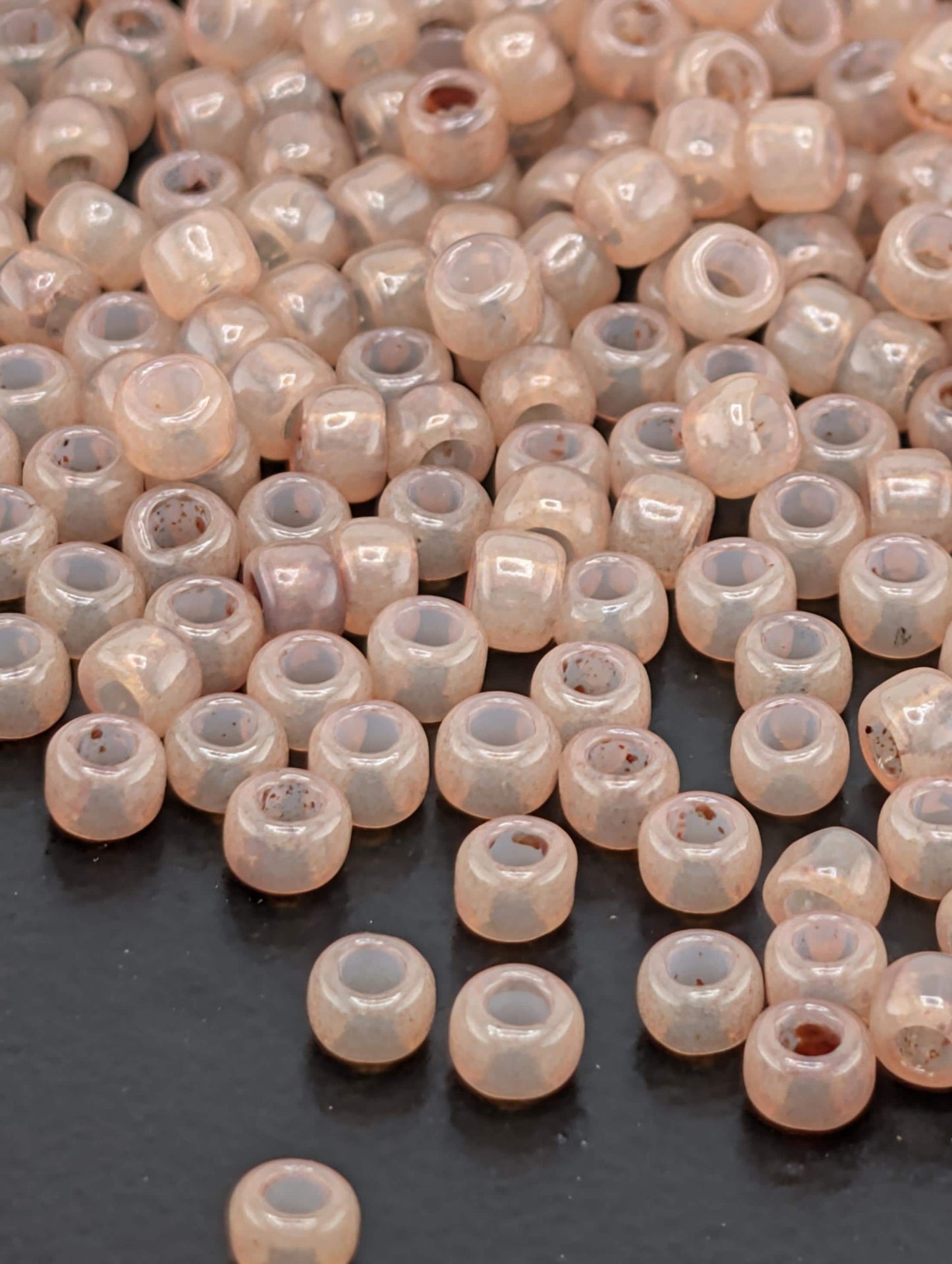 a collection of small, clear beads scattered on a dark surface.