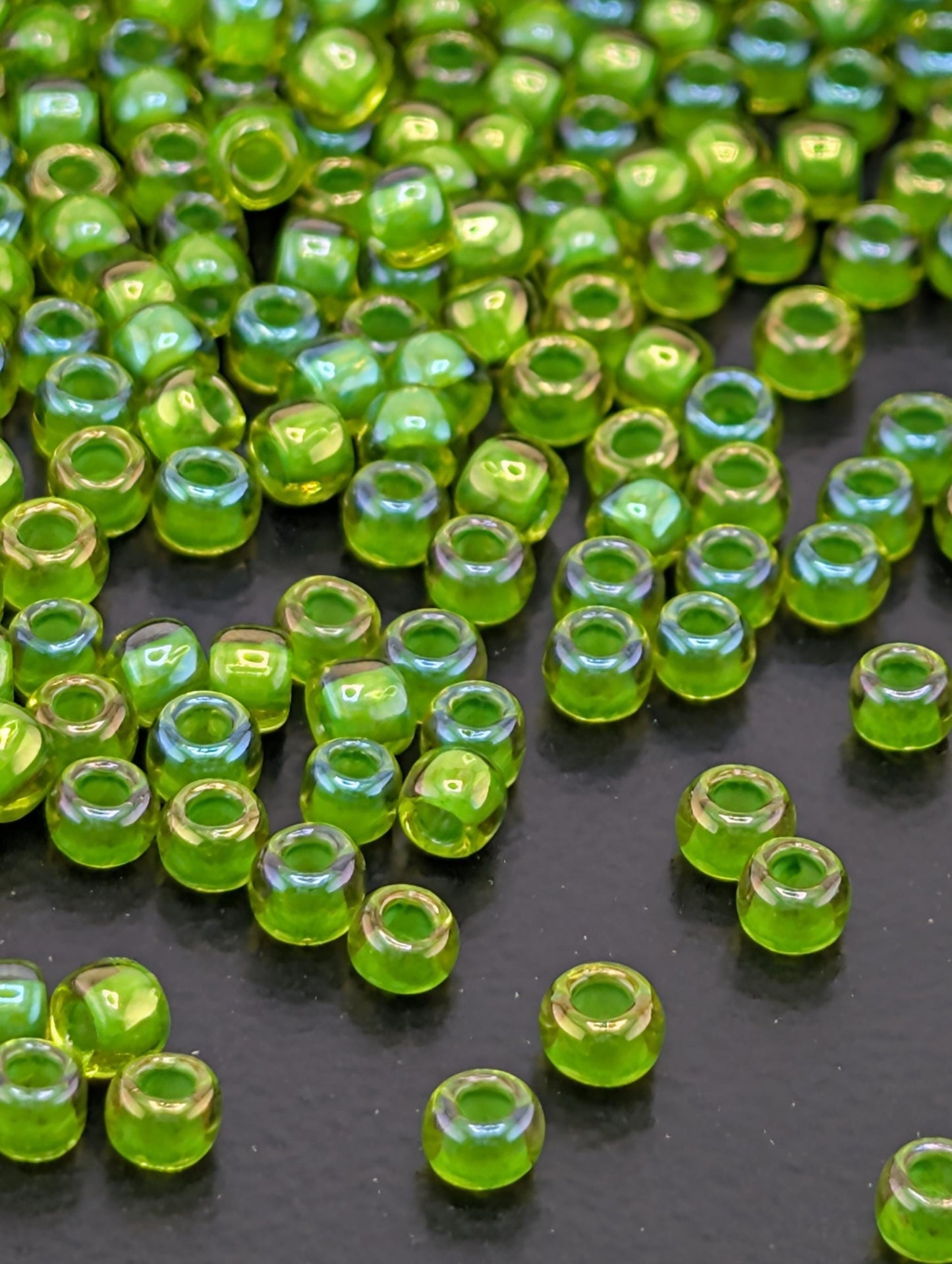a collection of small, round green beads scattered across a dark surface.