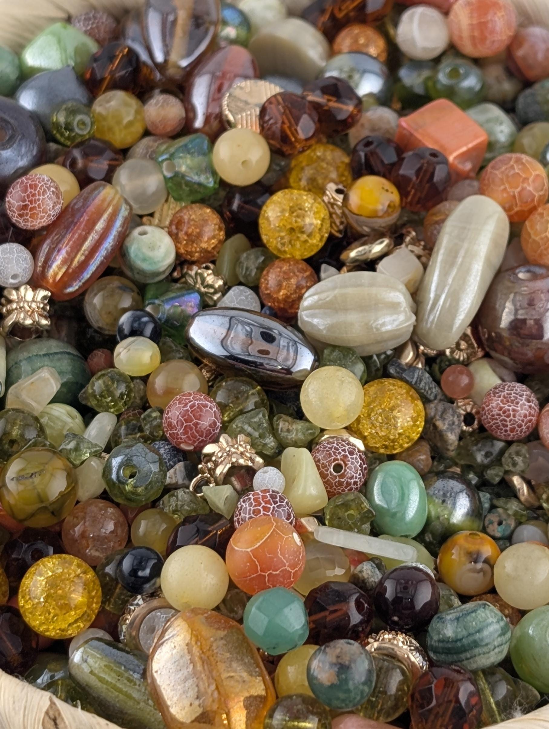 The image is a close-up of a variety of colorful beads and glass beads, including multicolored glass beads, multicolored glass beads, and multicolored glass beads.