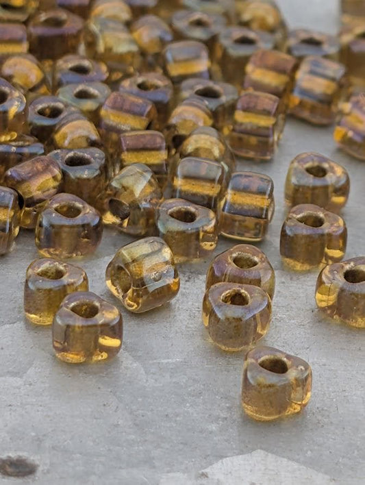 a collection of small, clear glass beads scattered on a surface.
