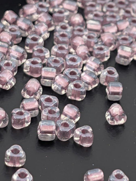 a collection of clear glass beads scattered on a dark surface.
