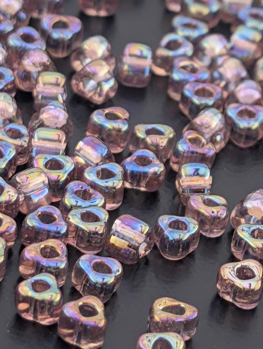 a collection of small, clear beads scattered on a dark surface.