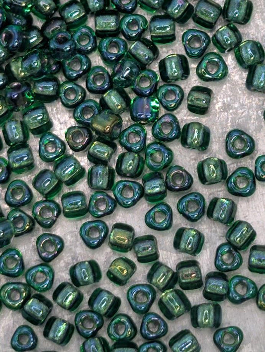 a collection of green glass beads scattered across a surface.