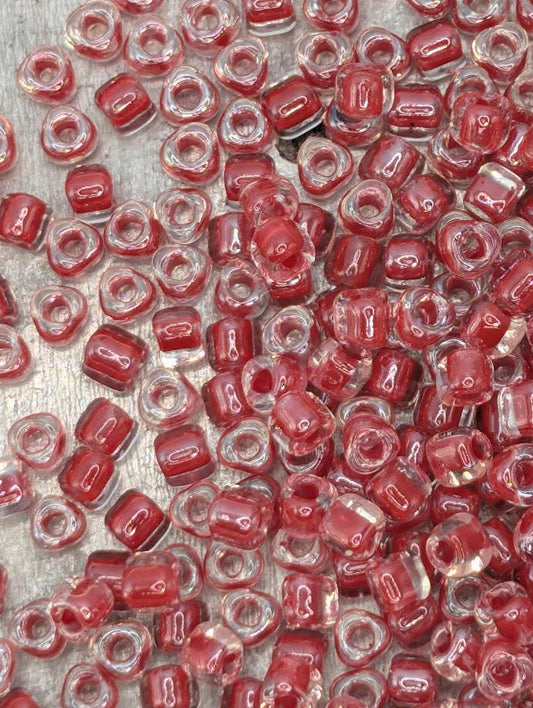 a close-up view of numerous red and clear beads scattered across a surface.