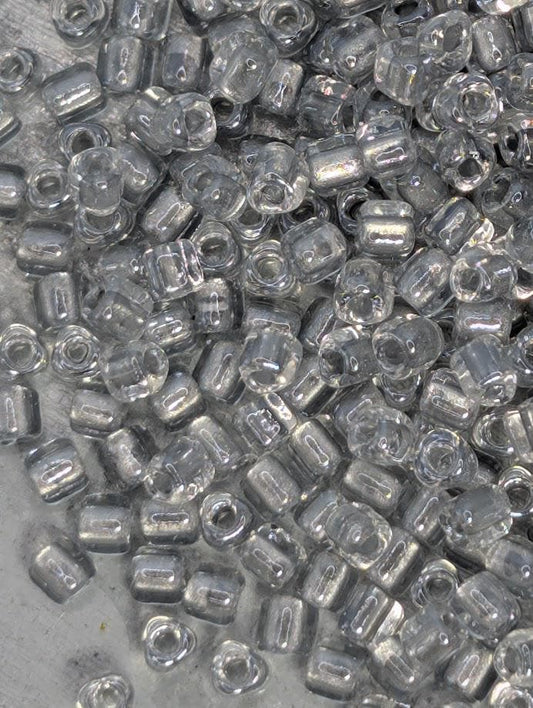 numerous clear glass beads scattered across a surface.