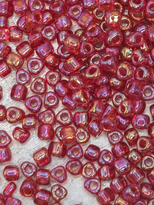 a close-up view of numerous red glass beads scattered across a surface.