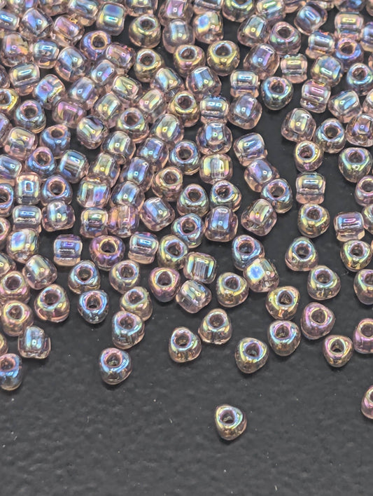 a collection of small, clear beads scattered on a dark surface.
