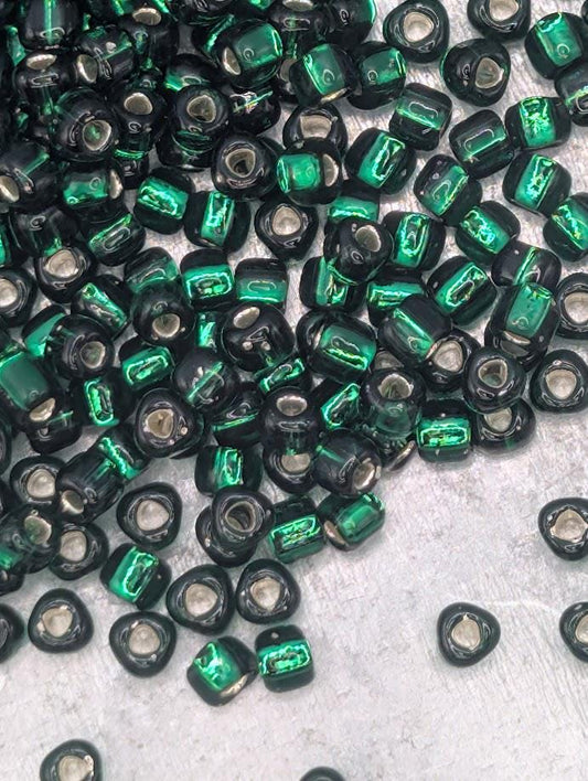 a collection of green and black beads scattered on a surface.