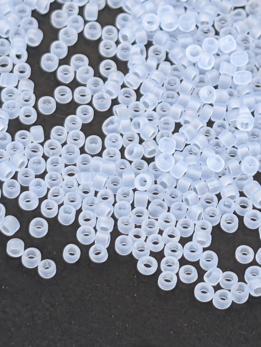 a collection of small, clear plastic beads scattered on a dark background.