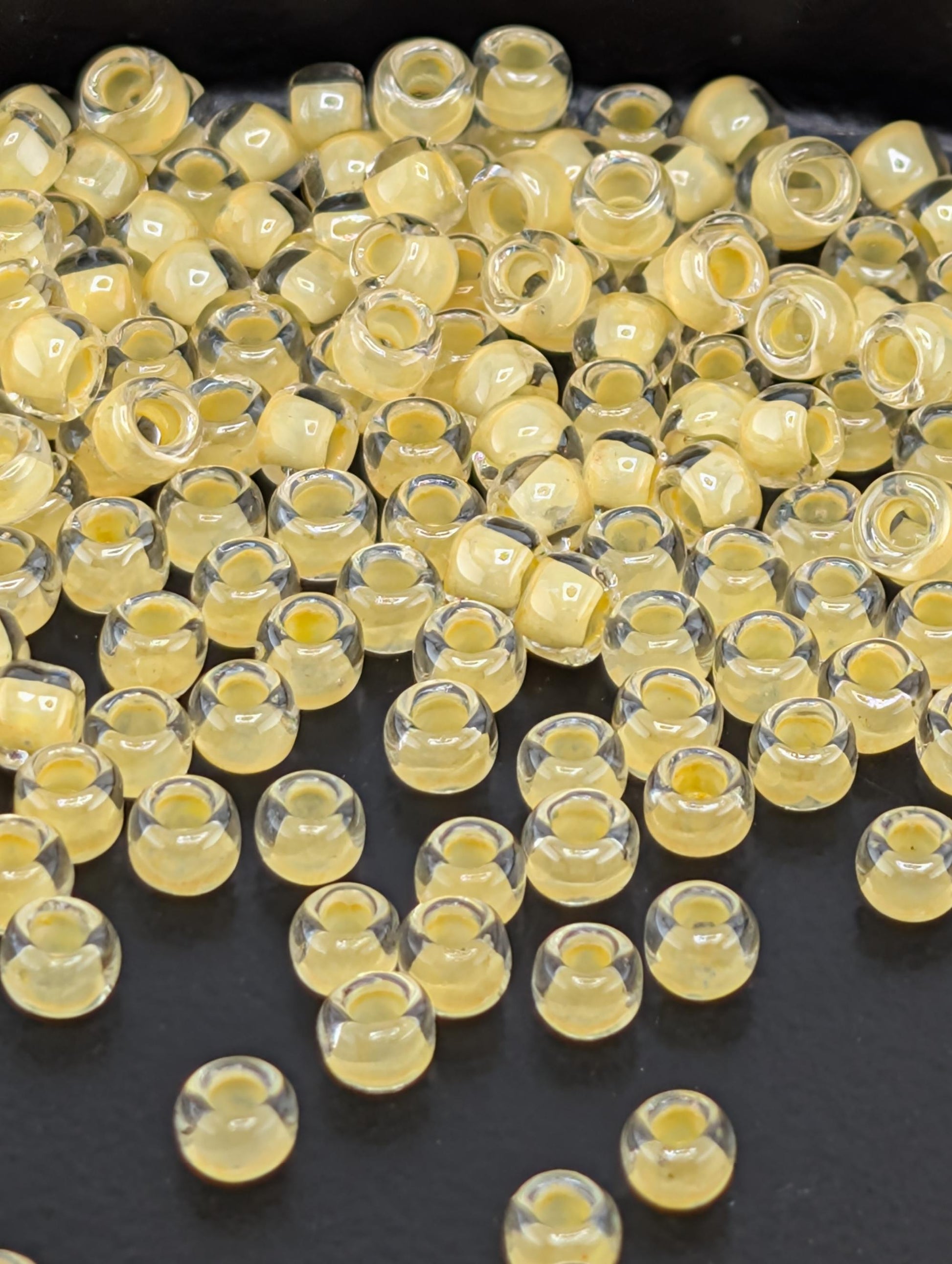 a collection of small, clear beads scattered on a dark surface.