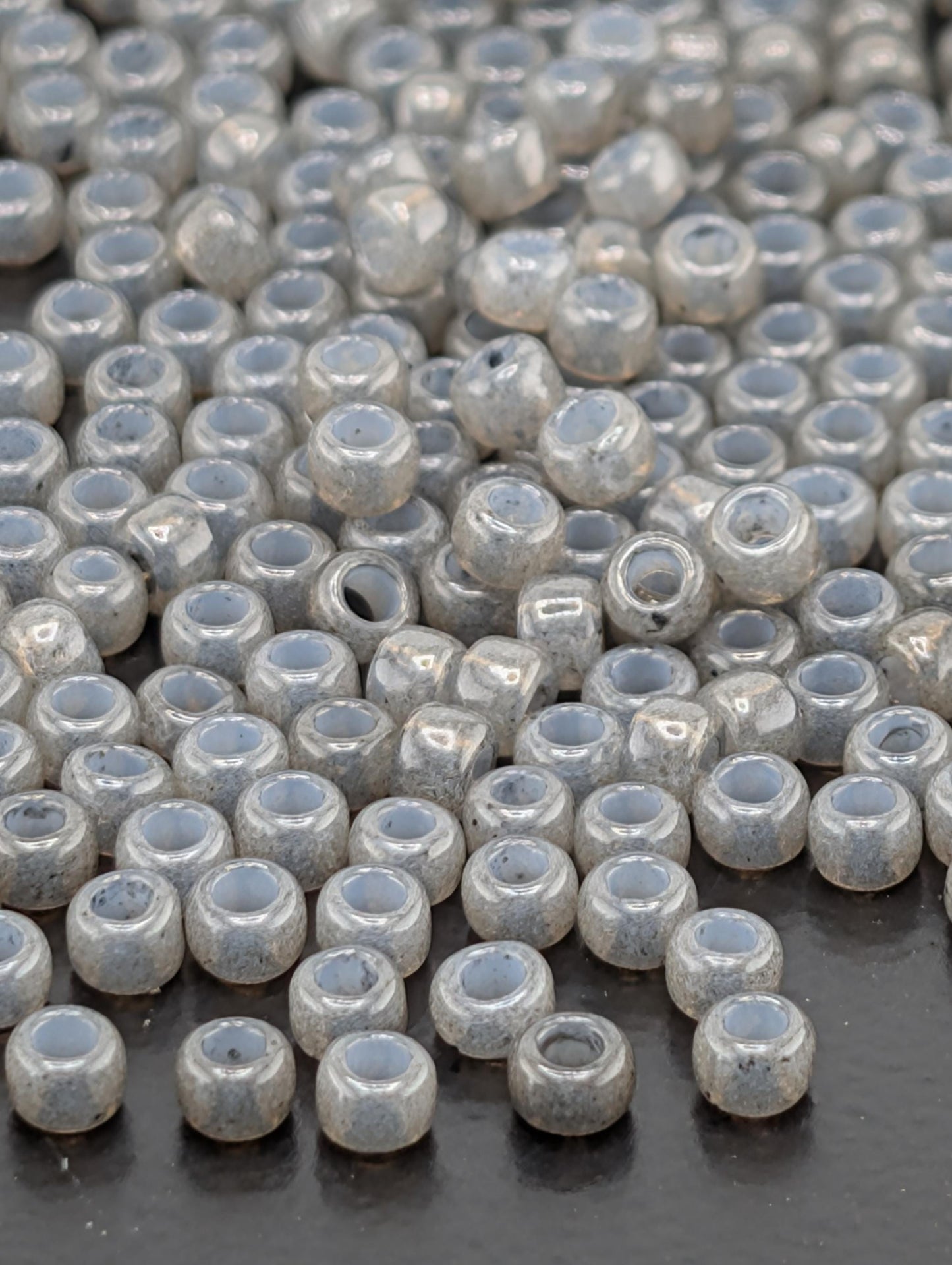 a large number of small, round beads scattered across a dark surface.