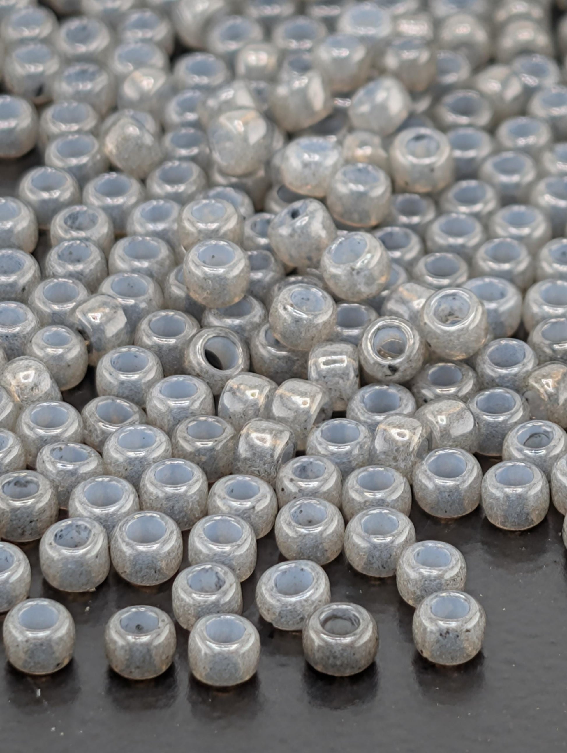 a large number of small, round beads scattered across a dark surface.
