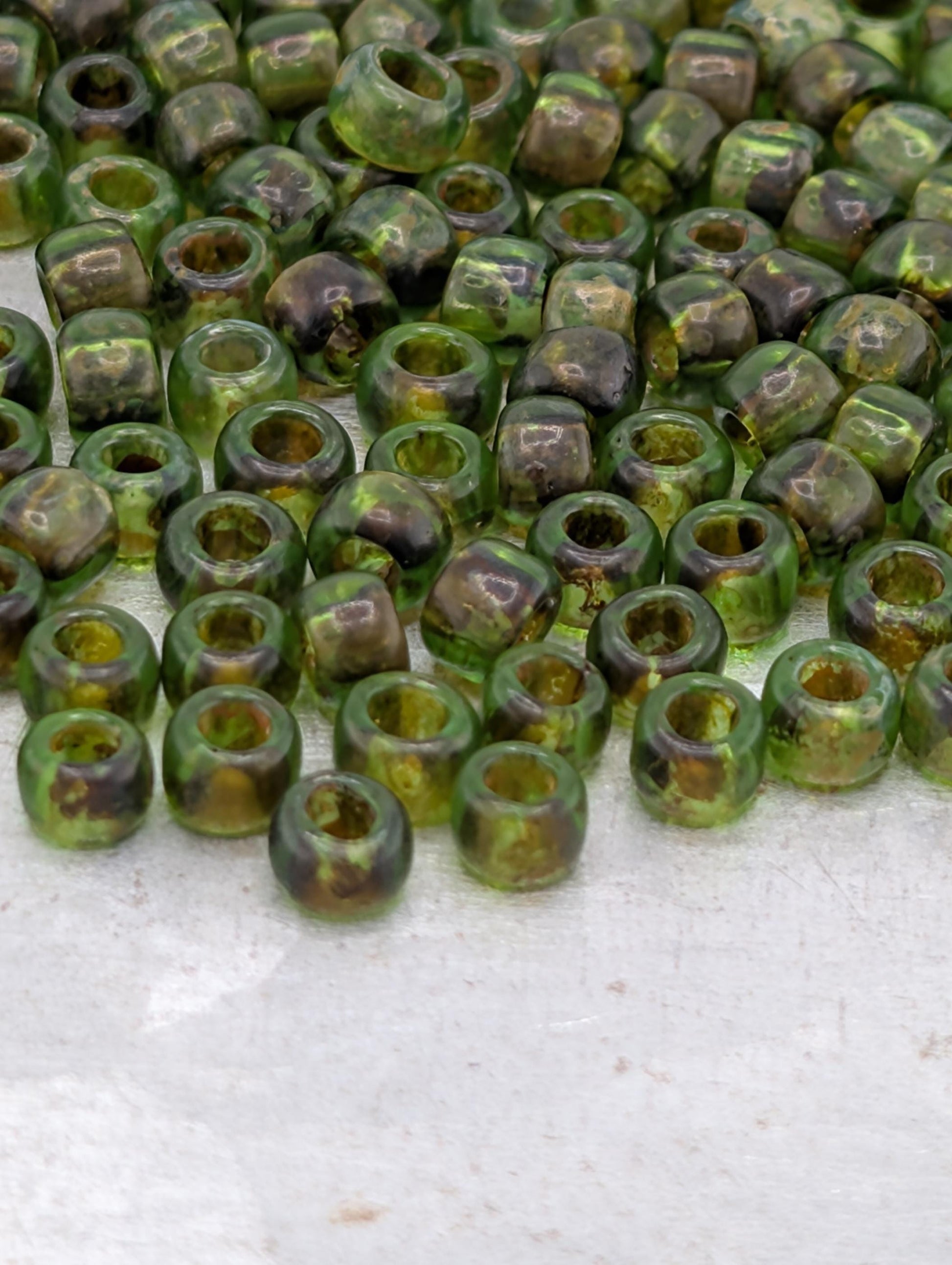 a large number of green glass beads scattered across a surface.